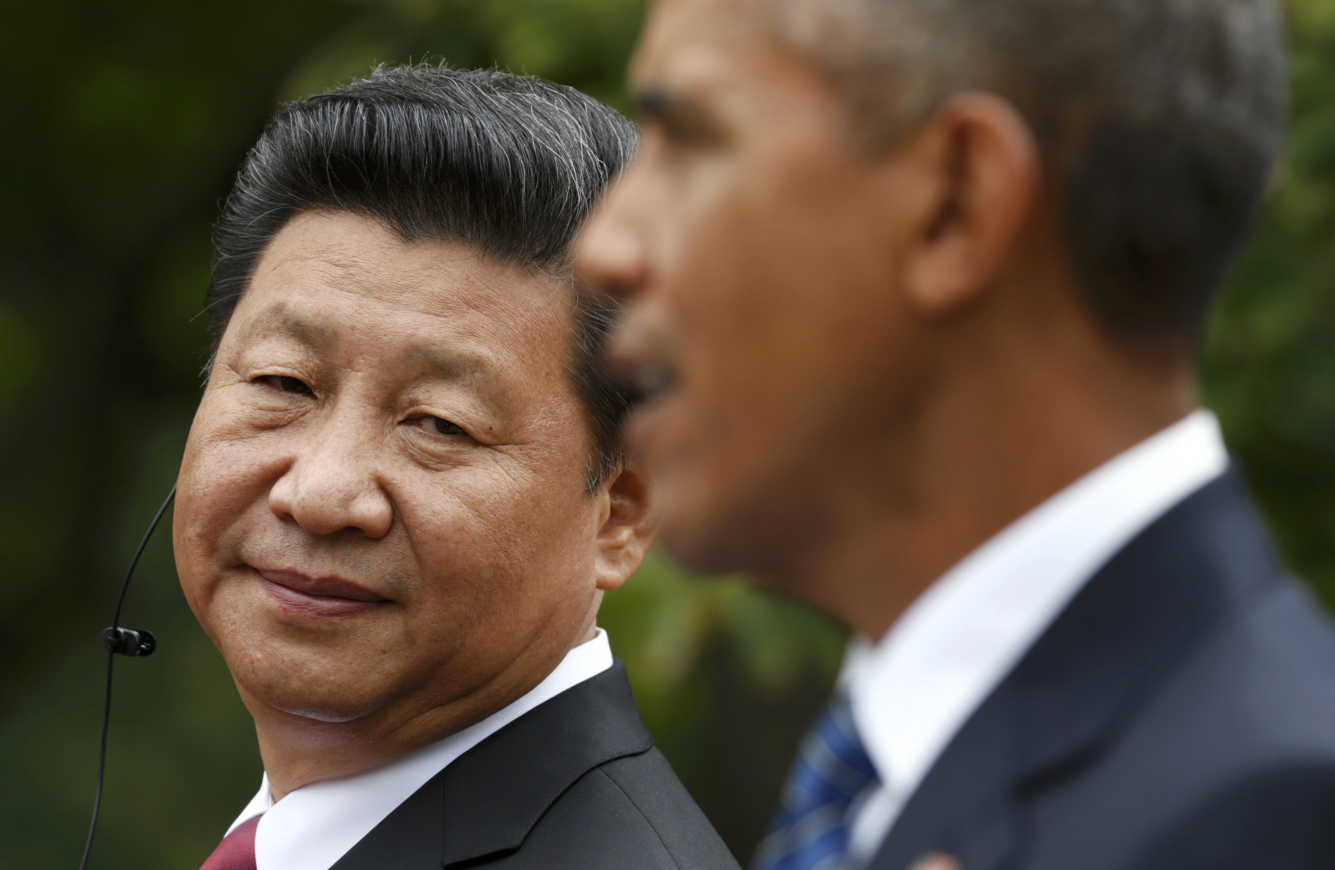 Chinese President Xi Jinping (L) listens to U.S. President Barack Obama during a joint news conference in the Rose Garden at the White House in Washington September 25, 2015. REUTERS/Kevin Lamarque