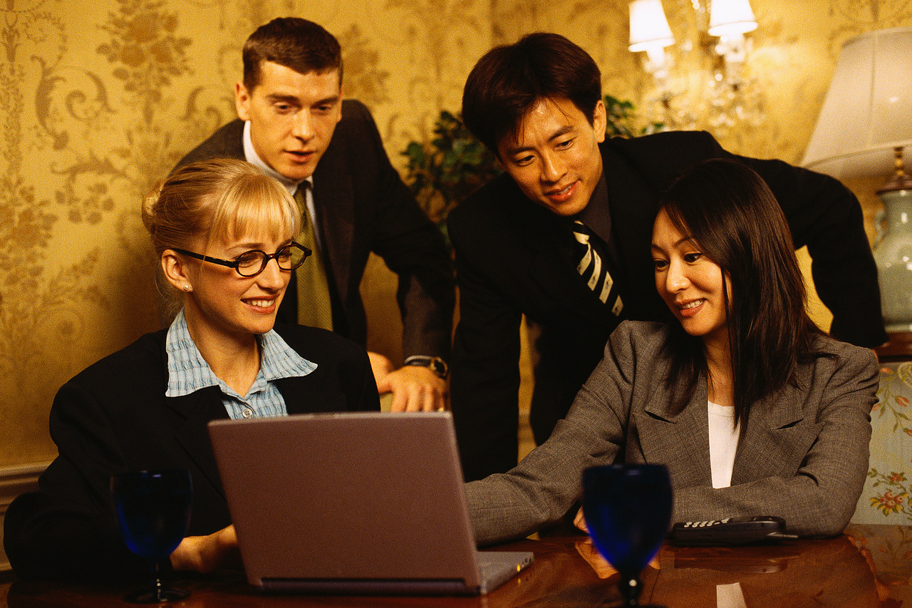 Business People Gathered Around Laptop